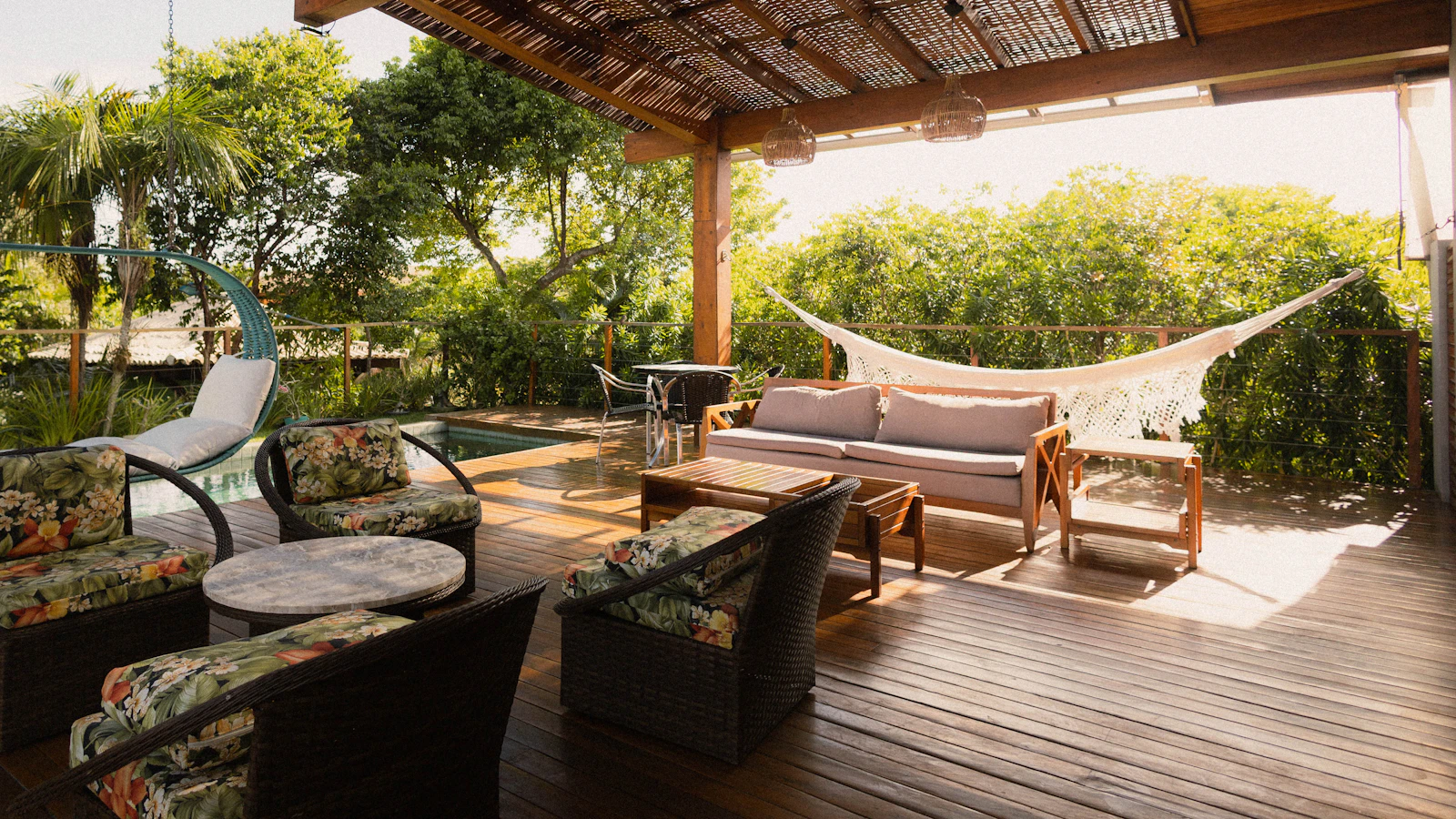 A guesthouse terrace with a plunge pool at dusk and a phone showing a booking confirmation